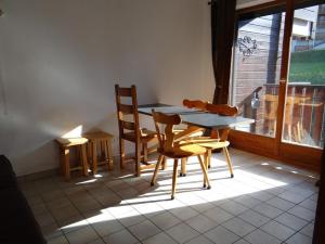 einen Tisch und Stühle in einem Zimmer mit Fenster in der Unterkunft Studio Saint-Jean-d'Aulps, 1 pièce, 5 personnes - FR-1-573-62 in Saint-Jean-dʼAulps