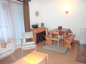Una sala de estar con una mesa y sillas y un escritorio. en Grand studio 2* proche pistes avec piscine et parking - FR-1-573-64, en Saint-Jean-dʼAulps