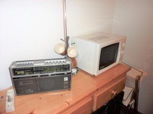 Un microondas y un televisor sobre una mesa de madera. en Grand studio 2* proche pistes avec piscine et parking - FR-1-573-64, en Saint-Jean-dʼAulps