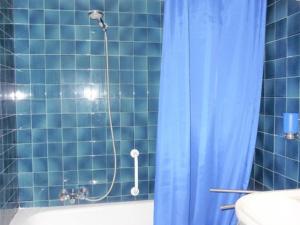 baño de azulejos azules con ducha y cortina de ducha en Grand studio 2* proche pistes avec piscine et parking - FR-1-573-64, en Saint-Jean-dʼAulps 20 fotos más