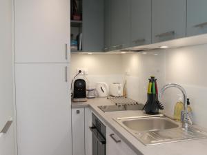 - une cuisine avec des placards blancs et un évier dans l'établissement Appartement Les Sables-d'Olonne, 3 pièces, 4 personnes - FR-1-485-121, à Les Sables-dʼOlonne