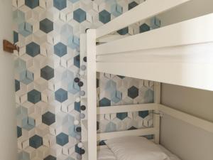 a kids bedroom with bunk beds and a hexagonal wall at Appartement Les Sables-d'Olonne, 3 pièces, 4 personnes - FR-1-485-121 in Les Sables-d'Olonne