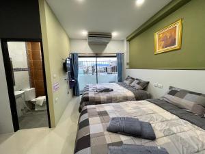 two beds in a room with green walls at Variety winner hostel in Hat Yai