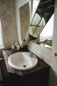 ein Badezimmer mit einem Waschbecken und einem Spiegel auf der Theke in der Unterkunft Ferienzimmer direkt am See in Priepert