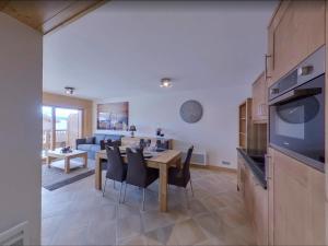 cocina y sala de estar con mesa y sillas en Appartement Villard-sur-Doron, 3 pièces, 6 personnes - FR-1-293-354, en Villard-sur-Doron