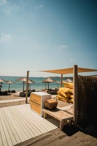 Soros Beach Antiparos في Agios Georgios: شاطئ فيه صندوق ومظلات والمحيط