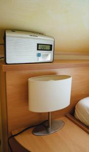 a room with a clock and a radio on a wall at Ferienzimmer direkt am See in Priepert