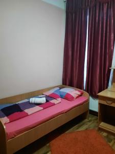 een bed in een kamer met een paars gordijn bij NENSI in Prokuplje