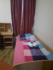 a small bedroom with a bed and a desk at NENSI in Prokuplje +4 photos