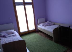 two beds in a room with two windows at NENSI in Prokuplje