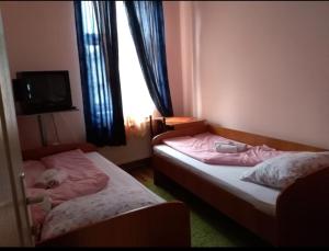 two twin beds in a room with a window at NENSI in Prokuplje