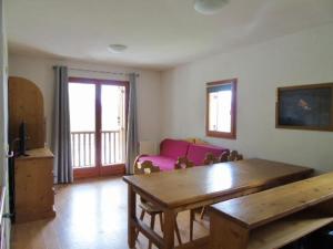 sala de estar con mesa y sofá rosa en Appartement Valfréjus, 3 pièces, 8 personnes - FR-1-561-95, en Modane