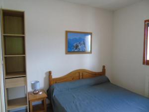 1 dormitorio con 1 cama y una foto en la pared en Appartement Valfréjus, 3 pièces, 8 personnes - FR-1-561-95, en Modane