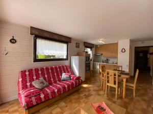 un soggiorno con divano rosso e una cucina di Studio La Clusaz, 1 pièce, 4 personnes - FR-1-437-92 a La Clusaz