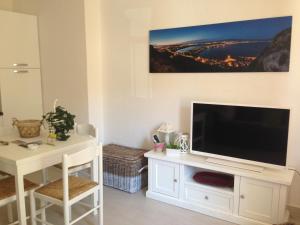 a living room with a large television on a white entertainment center at Car'Loft beachside in Cagliari