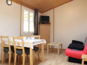 comedor con mesa y sofá rojo en Chalet Saint-Pierre-d'Oléron, 3 pièces, 4 personnes - FR-1-246A-132, en Saint-Pierre-dʼOléron