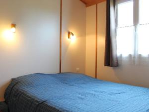 Un dormitorio con una cama azul y una ventana en Chalet Saint-Pierre-d'Oléron, 3 pièces, 4 personnes - FR-1-246A-132, en Saint-Pierre-dʼOléron