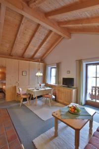 a living room with a table and a dining room at Berggasthaus Weingarten in Ruhpolding