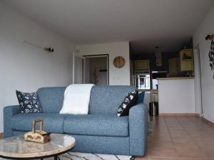 - un canapé bleu dans le salon avec une table dans l'établissement Appartement Bolquère-Pyrénées 2000, 3 pièces, 4 personnes - FR-1-592-40, à Font-Romeu