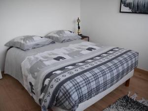 - un lit dans une chambre avec une couverture dans l'établissement Appartement Bolquère-Pyrénées 2000, 3 pièces, 4 personnes - FR-1-592-40, à Font-Romeu
