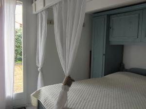 1 dormitorio con cama y ventana en Maison Soulac-sur-Mer, 2 pièces, 5 personnes - FR-1-648-88, en Soulac-sur-Mer