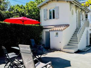 dom ze stołem, krzesłami i parasolem w obiekcie Studio refait à neuf, 21m², 3 pers., jardin privatif, plage et commerces à proximité, parking inclus - FR-1-433-94 w Arcachon +2 zdjęcia