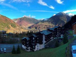budynek na wzgórzu z górami w tle w obiekcie 3 pièces skis aux pieds avec balcon à Saint-Jean-d'Aulps - FR-1-573-80 w mieście Saint-Jean-dʼAulps