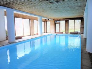 duży basen z błękitną wodą w budynku w obiekcie Studio chaleureux proche des pistes avec piscine et parking - FR-1-573-89 w mieście Saint-Jean-dʼAulps