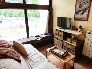 a living room with a bed and a tv and a window at Studio Isola 2000, 1 pièce, 4 personnes - FR-1-292-179 in Isola