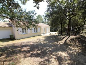 een huis met een schaduwrijke tuin ervoor bij Maison Saint-Georges-d'Oléron, 5 pièces, 6 personnes - FR-1-246A-131 in Saint-Georges-dʼOléron