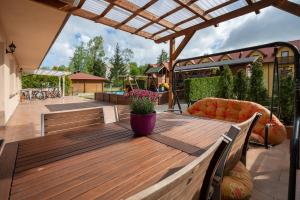 Un patio con una mesa de madera y un sofá. en Pasja Jastrzębia Góra, en Jastrzębia Góra