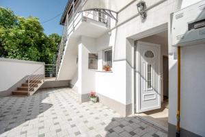 ein weißes Haus mit einer weißen Tür und einer Treppe in der Unterkunft Apartman MirA in Sarajevo