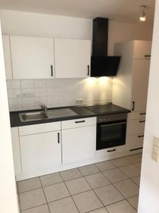 eine Küche mit weißen Schränken und einer Spüle in der Unterkunft Monteurwohnung am Landgrafen in Worms