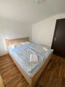 una camera con un grande letto e pavimenti in legno di Apartmani LALA Canj a Čanj