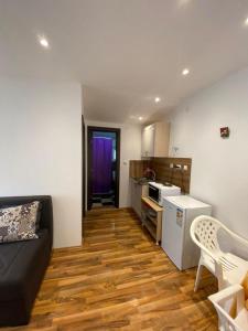 a living room with a black couch and a kitchen at Apartmani LALA Canj in Čanj