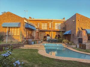 a brick house with a swimming pool in the yard at Amatola Mountain View in King Williamʼs Town