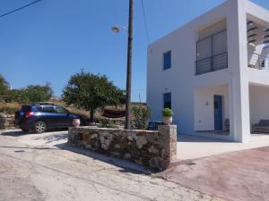 a car parked in front of a white house at Theros house in Kythira