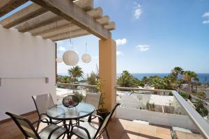 eine Terrasse mit einem Tisch und Stühlen auf dem Balkon in der Unterkunft Apartamento Relax and Dream in Pájara