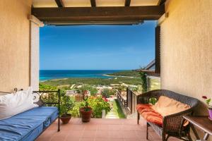 balcone con divano e vista sull'oceano di Villetta Fabi a San Teodoro