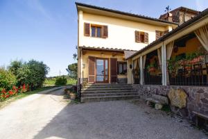 a house with a porch and a bench on a road at Agriturismo Poggio Pistolese in Montaione