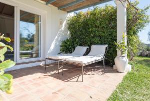 a patio with two white chairs on a patio at La Casita by Teresa in Marbella