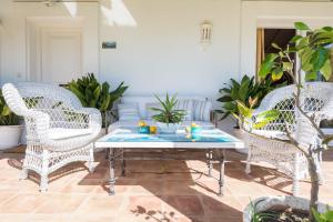 a living room with white wicker chairs and a coffee table at La Casita by Teresa in Marbella