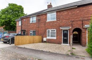 a brick house with a car parked in front of it at Piccadilly Place - 3 Bedroom House in York