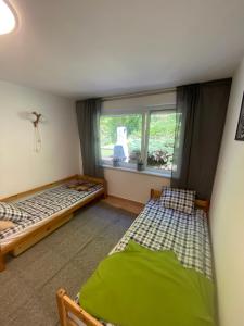 sypialnia z 2 łóżkami i oknem w obiekcie Domek letniskowy Wielonek 4 w mieście Cierplewo