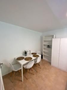 a dining room with a table and white chairs at Domek letniskowy Wielonek 4 in Cierplewo