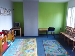 a room with green walls and a bed and a rug at Rekreační středisko Královec in Valašské Klobouky