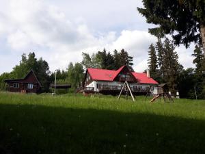 a house with a red roof in a field at Rekreační středisko Královec in Valašské Klobouky