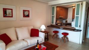 a living room with a white couch and a kitchen at ATLANTICO 24 in Puerto de Santiago