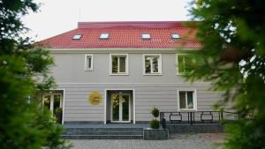 un grand bâtiment blanc avec un toit rouge dans l'établissement CORVIN HOUSE, à Hunedoara