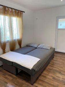 1 dormitorio con 1 cama grande y ventana en Apartmani LALA 2 Canj en Čanj